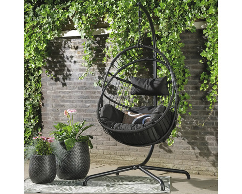 Hängstol med kuddar och blomkrukor i trädgården