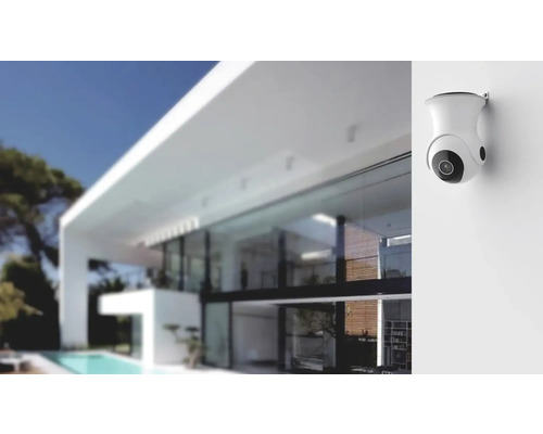 Övervakningskamera för väggmontage framför ett modernt hus