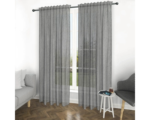Vardagsrum med grå gardiner framför ett fönster