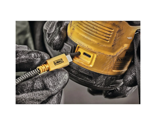 En hand med en arbetshandske sätter in en USB-kabel i en elektronisk enhet av märket DeWalt.