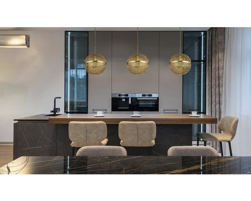 Modernt kök med tre gyllene klotformade hänglampor ovanför en köksö med barstolar