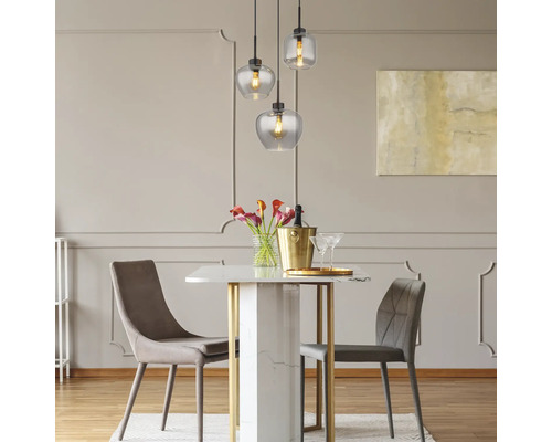 Matsal med matbord, stolar och pendellampor med glasskärmar