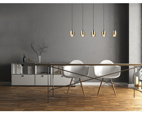 Matsal med matbord, stolar och hänglampor ovanför bordet