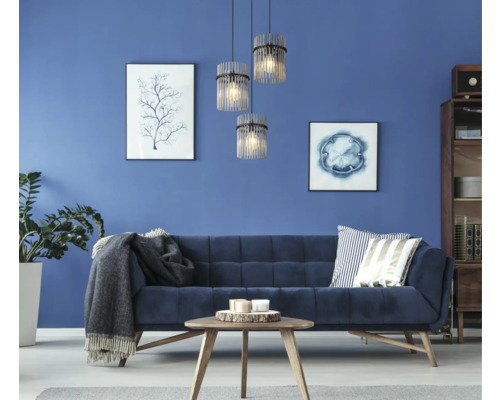 Vardagsrum med soffa, bord, krukväxt och tre hänglampor