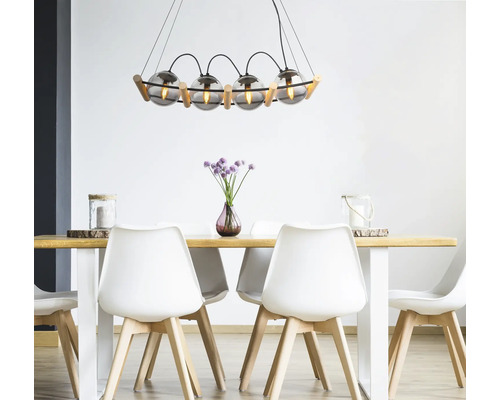 Matbord med hängande lampa i glas och trä, kombinerat med vita stolar för en ljus och modern atmosfär.