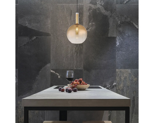 Scen med en hänglampa över ett matbord med ett glas vin och frukt