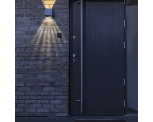 Utomhusvägglampa bredvid en ytterdörr på en tegelvägg