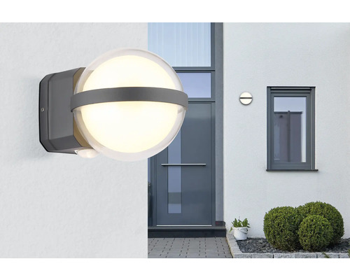 Lysande utomhuslampa med rörelsesensor på en husvägg