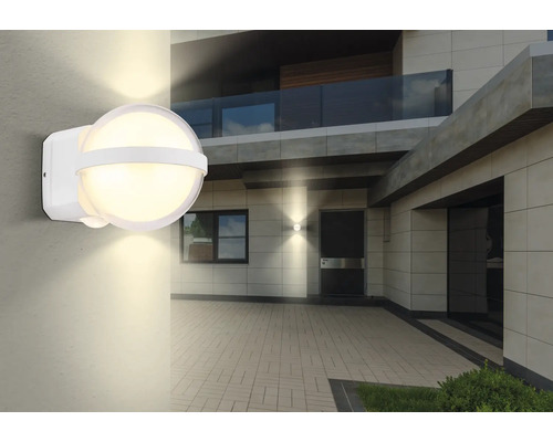 Lysande utomhusvägglampa med rörelsesensor på en husvägg