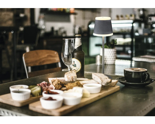 Bordsdekoration med lampa, drycker och mat.