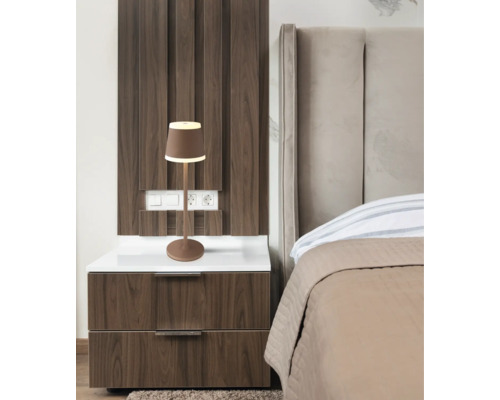 Sovrum med sängbord, säng och lampa