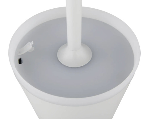 Detaljbild av en vit toalettborste med behållare.