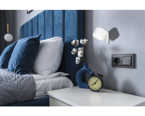 Sovrum med säng, sängbord, lampa och dekoration