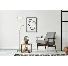 Golvlampa med läsarm bredvid sidobord och fåtölj i ett ljust rum