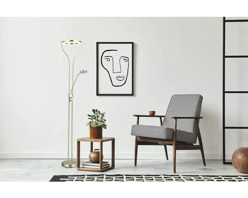Golvlampa med läsarm bredvid sidobord och fåtölj i ett ljust rum