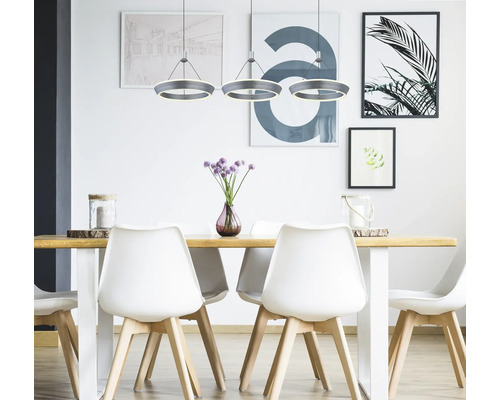 Matsal med träbord, vita stolar och runda hänglampor