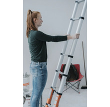 Kvinna håller en teleskopstege i ett rum.