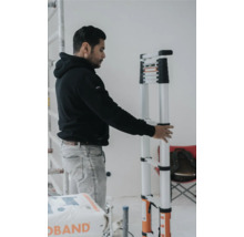 Man håller en teleskopisk stege i ett inre