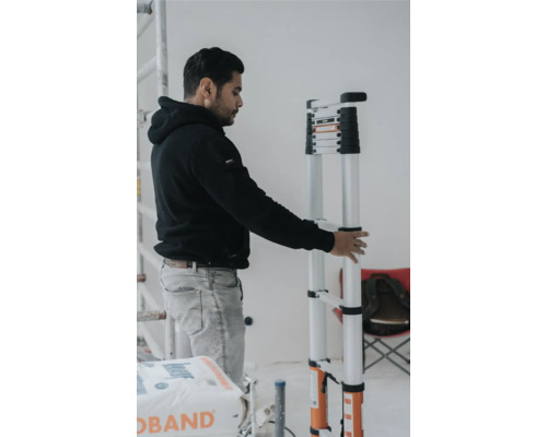 Man håller en teleskopisk stege i ett inre