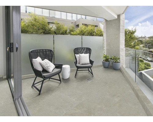 Balkongscen med kakelgolv, stolar och bord