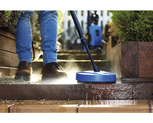 Person rengör terrass med ytrengörare och högtryckstvätt
