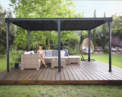 Övertäckt lusthus med sittgrupp och hängande stol i trädgården