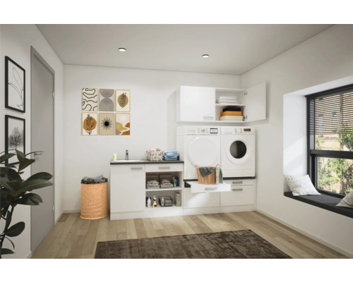 Ljust tvättrum med tvättmaskin, torktumlare, handfat och förvaringsmöbler.