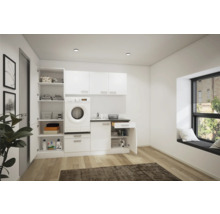 Ljust tvättrum med tvättmaskin, hyllor och skåp