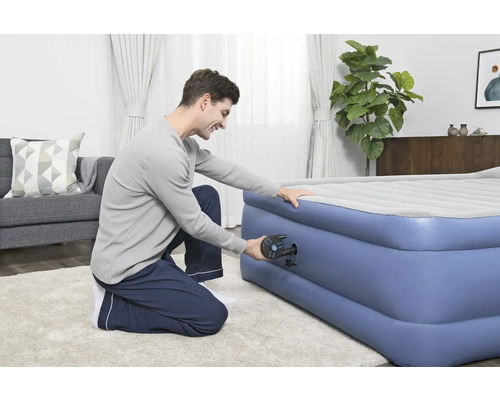 Man pumpar upp en uppblåsbar madrass med en pump