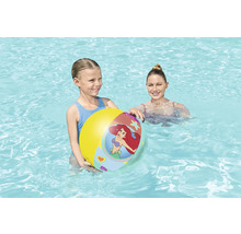 Flicka håller en uppblåsbar vattenboll i poolen