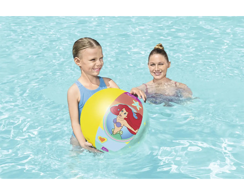 Flicka håller en uppblåsbar vattenboll i poolen