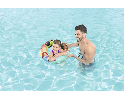 Barn med badring i poolen med vuxen