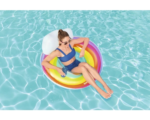 Kvinna kopplar av på en uppblåsbar flytande ö i poolen