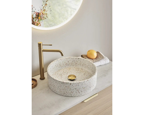 Tvättställ på bänkskiva i badrum med armatur och belyst spegel