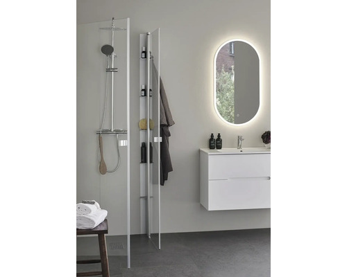 Badrum med dusch, hylla och upplyst spegel