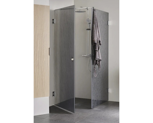 Duschkabin med duschsystem och badrock i badrummet