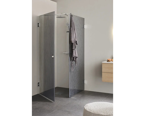 Duschkabin med duschhuvud och badrock i ett badrum