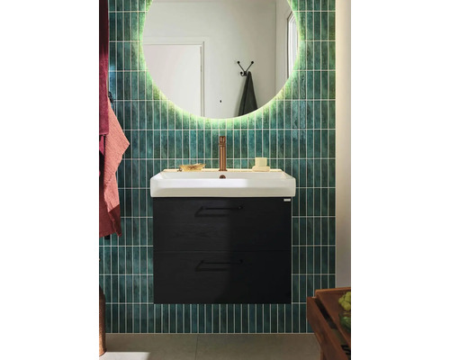 Badrum med tvättställ, underskåp och spegel med belysning framför väggplattor