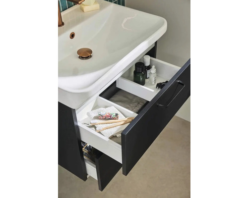 Tvättställsskåp med öppna lådor i badrummet.