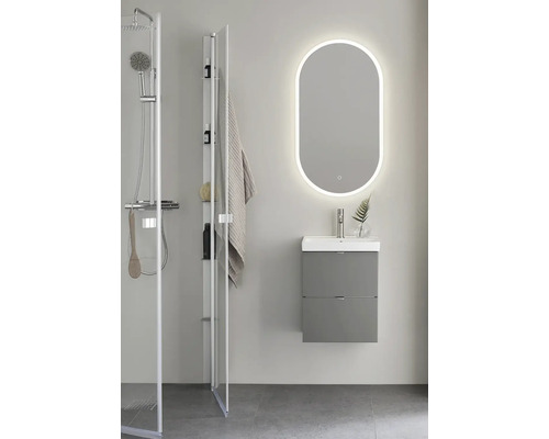 Badrum med dusch, tvättställsskåp och spegel