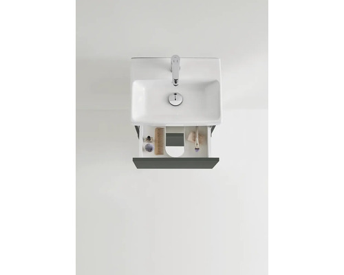 Vy från ovan av ett tvättställ med öppen låda och badrumsartiklar