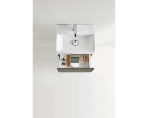 Tvättställ med öppen utdragslåda och badrumsartiklar ovanifrån