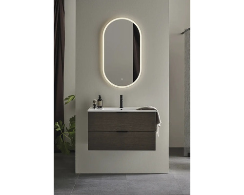 Badrum med tvättställsskåp, handfat och belyst spegel