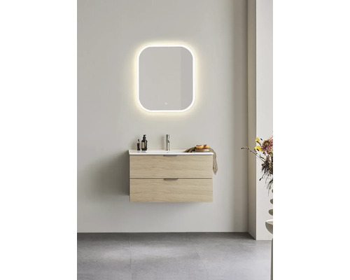 Badrum med tvättställsskåp, tvättställ och belyst spegel