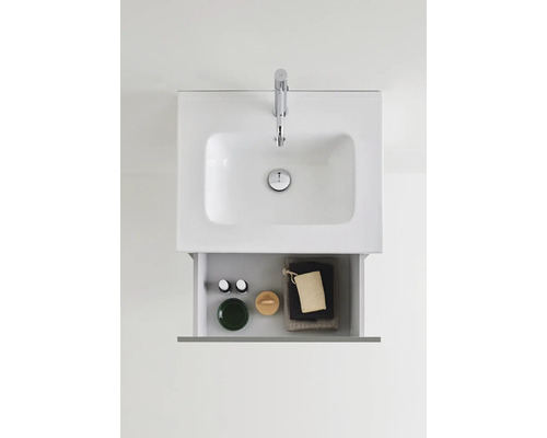 Tvättställsskåp med öppen låda, med badrumsartiklar inuti