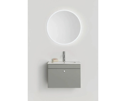 Tvättställ med rund spegel och belysning i badrummet.