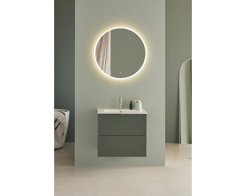 Badrum med rund spegel med belysning, tvättställsskåp med två lådor och badkar