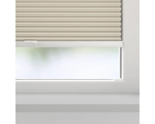 Beige plisségardiner framför ett fönster för ljusreglering.