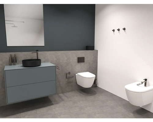 Badrum med tvättställ, spegel, toalett och bidé.