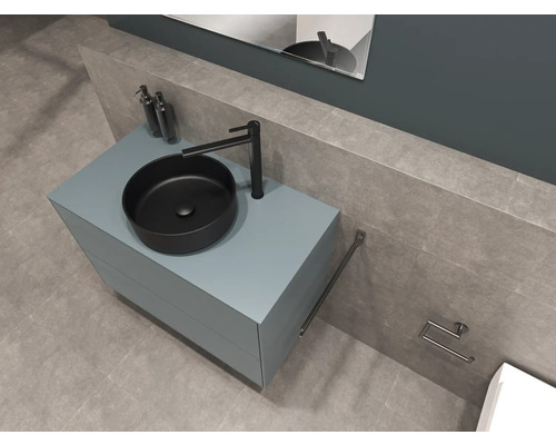 Modernt badrum med tvättställsskål, tvättställsskåp, armatur, handdukshållare och toalettpappershållare.